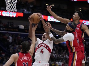 Toronto Raptors forward Scottie Barnes (4) battles under the basket with New Orleans Pelicans guard Dyson Daniels (11), forward Brandon Ingram and forward Herbert Jones, right, in the first half of an NBA basketball game in New Orleans on Monday.