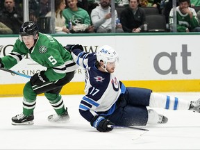 Stars defenceman Nils Lundkvist (left) chases the puck after getting past Jets centre Adam Lowry in Dallas last night.