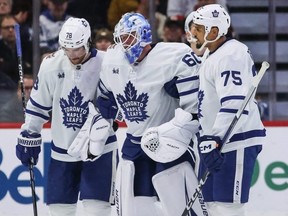 The Leafs' TJ Brodie, left, and Ryan Reaves, right, assist injured goaltender Joseph Woll off the ice after he got hurt in a game against the Senators in early December.