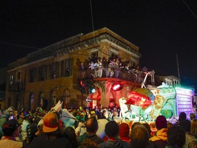 Spectators watch from the balcony of Anna's as Krewe du Vieux parades through the Marigny neighborhood in New Orleans, Saturday, Jan. 27, 2024.