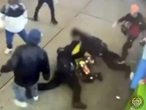 This image taken from video provided by the New York City Police Department shows officers confronting a group near New York's Times Square, Jan. 27, 2024, bringing a man in a bright yellow coat down to the sidewalk and the chaotic scene that unfolds.
