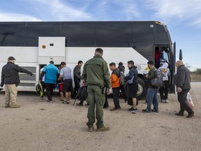 Immigrants file into a U.S. Customs and Border Protection bus after crossing the U.S.-Mexico border in Eagle Pass, Texas on Jan. 7, 2024.