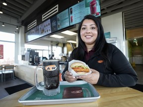 Priya Dhillon, who runs several A&W locations with her family, holds a spicy piri piri potato buddy at an A&W location in Mississauga, Ont., on Friday, Feb. 9, 2024.