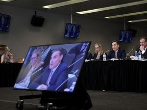 Mirko Bibic, president and CEO of BCE and Bell Canada is seen on television screens as he speaks during a CRTC hearing in Gatineau, Que., on Wednesday, Feb. 19, 2020. Members of Parliament have invited several top executives from BCE Inc. and Bell Canada to testify later this month about the company's decision to cut about nine per cent of its workforce this year.