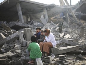 American officials say they are still trying to sort out what caused the Israeli military to detain members of a Canadian-American family in the Gaza Strip. Palestinians sit by the destruction from the Israeli bombardment of the Gaza Strip in Rafah on Monday, Feb. 12, 2024.