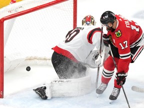 Blackhawks winger Nick Foligno (17) has the puck go into the net off him and behind Senators goaltender Joonas Korpisalo for a goal in the first period of Saturday's game in Chicago.