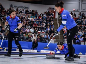 Manitoba skip Kate Cameron delivers a stone while lead Mackenzie Elias, right, and second Kelsey Rocque get ready to sweep as they play Team Alberta in the Page playoff 3-v-4 game during the Scotties Tournament of Hearts at the WinSport Event Centre in Calgary on Saturday, Feb. 24, 2024.