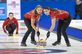 Kerri Einarson watches her shot as sweepers Briane Harris (left) and Shannon Birchard bring it to the house.