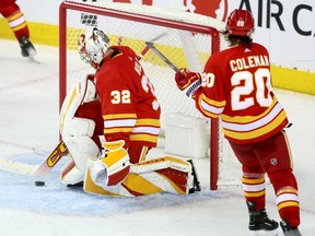 Calgary Flames goalie Dustin Wolf and forward Blake Coleman react after a goal by San Jose Sharks forward Luke Kunin at the Scotiabank Saddledome in Calgary on Thursday, Feb. 15, 2024.
