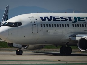 Pilots taxi a WestJet Boeing 737-700 aircraft to the runway for departure from Vancouver International Airport, in Richmond, B.C., on Friday, May 19, 2023. A flight from Vancouver to Toronto made an unscheduled stop after a passenger attempted to open a door. WestJet says in an email that Flight 710 diverted to Winnipeg after the incident on Friday.