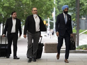 . Former Liberal MP Raj Grewal, right, walks with his lawyers as they make their way to court, Monday, July 18, 2022 in Ottawa.