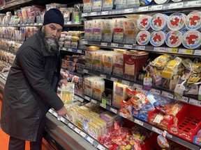NDP Leader Jagmeet Singh points to a $20 package of cheese during a visit to a Loblaws grocery store in Ottawa on Wednesday Feb. 21, 2024.