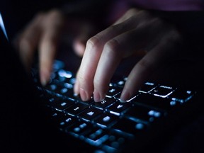 A woman types on a computer keyboard.