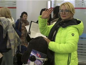 A tourist waves as a group of Russian tourists, likely the first foreign travelers from any country to enter North Korea since the pandemic arrive at the Pyongyang International Airport in Pyongyang, North Korea, Friday, Feb. 9, 2024.
