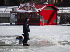 A BeaverTails stand is seen past crews flooding the ice surface of the Rideau Canal Skateway, as the National Capital Commission works to re-open it to skaters, in Ottawa, on Saturday, Feb. 17, 2024. A section of Ottawa's iconic Rideau Canal is to open today for a second time this winter as slightly chillier temperatures return to the nation's capital.