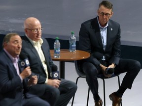 Winnipeg Jets co-owner Mark Chipman (right) listens as NHL commissioner Gary Bettman responds to a question during a fireside chat at Canada Life Centre in Winnipeg on Tuesday, Feb. 27, 2024. Deputy commissioner Bill Daly is in the middle.