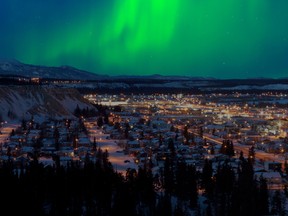 Strong northern lights light up the night sky over downtown Whitehorse, capital of the Yukon Territory, in winter.
