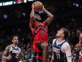 Immanuel Quickley of the Toronto Raptors goes to the net against Luka Doncic of the Dallas Mavericks.