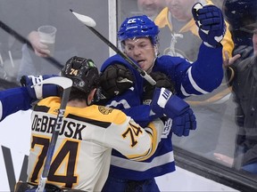 Boston Bruins left wing Jake DeBrusk (74) and Toronto Maple Leafs defenceman Jake McCabe (22) exchange blows.