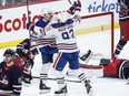 Edmonton Oilers' Zach Hyman (18) and Ryan Nugent-Hopkins (93) celebrate Hyman's game-winning goal against the Winnipeg Jets.