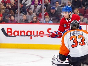Montreal Canadiens' Nick Suzuki takes a swing at the puck in front of Philadelphia Flyers' Samuel Ersson during the third period of a National Hockey League game in Montreal Thursday March 28, 2024. Susuki's shot beat Ersson but the referee ruled that he hit it with a high stick and disallowed the goal.