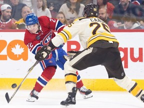 Canadiens' Cole Caufield shoots the puck past Boston Bruins Brandon Carlo in Montreal on Thursday March 14, 2024. "I'd say it's probably the toughest place to play as a young player," Caufield said of Montreal. "The fans just expect you to win, probably just because of the past and the history of winning (24 Stanley Cups)."
