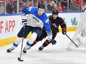 Logan Stankoven #10 of Canada battles for the puck against Joni Jurmo #4 of Finland in the IIHF World Junior Championship on August 20, 2022 at Rogers Place in Edmonton, Alberta, Canada.