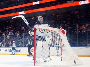 Connor Hellebuyck (37) of the Winnipeg Jets reacts to a first period goal by Cal Clutterbuck (15) of the New York Islanders at UBS Arena on March 23, 2024 in Elmont, N.Y. The Islanders defeated the Jets 6-3.