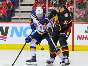 Calgary Flames defenceman Nikita Zadorov and St. Louis Blues forward Pavel Buchnevich battle for the puck during NHL action at the Scotiabank Saddledome in Calgary on Friday, December 16, 2022. Gavin Young/Postmedia