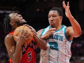 Toronto Raptors guard Immanuel Quickley (5) is fouled by Charlotte Hornets forward Grant Williams (2) during second half NBA basketball action in Toronto on Sunday, March 3, 2024.