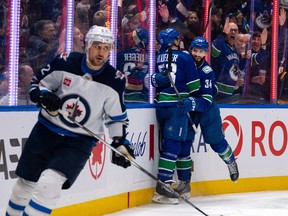 Vancouver Canucks' Teddy Blueger and Phillip Di Giuseppe celebrate Giuseppe's goal as Winnipeg Jets' Nino Niederreiter skates past during the game in Vancouver, Saturday, March 9, 2024. THE CANADIAN PRESS/Ethan Cairns
