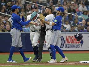 Tampa Bay Rays third base coach Brady Williams, center left, and shortstop Bo Bichette, right, try to break up a confrontation between Tampa Bay's Jose Caballero, center right, and Toronto Blue Jays reliever Genesis Cabrera, left, after Cabrera pushed Caballero during the seventh inning of a baseball game, Saturday, March 30, 2024, in St. Petersburg, Fla.