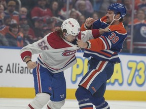 Sam Carrick (39) of the Edmonton Oilers, grapples with Michael Pezzetta (55) of the Montréal Canadiens at Rogers Place in Edmonton on March 19, 2024.