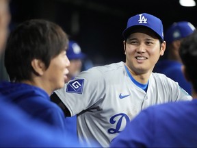 Los Angeles Dodgers designated hitter Shohei Ohtani, right, talks with interpreter Ippei Mizuhara during the ninth inning of an opening day baseball game against the San Diego Padres at the Gocheok Sky Dome in Seoul, South Korea on Wednesday.