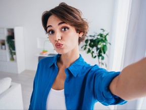 Photo of young woman pouting lips in selfie