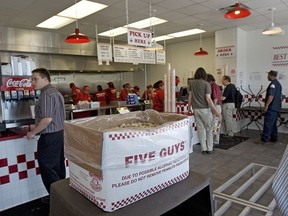 Customers wait in line to place their food order at the Five Guys Famous Burgers and Fries restaurant at a store in Washington, DC.