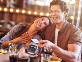 A woman swoons as her date pays for the bill at a restaurant.