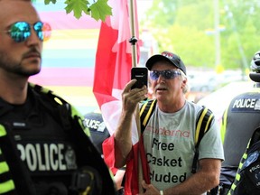 A man shoots a cellphone video while London police officers kept demonstrators and counter-protesters separated at a Pride event in Wortley Village on Saturday June 10, 2023. (Dale Carruthers / The London Free Press)