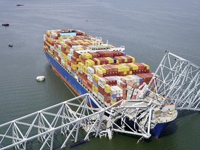 In this aerial image released by the Maryland National Guard, the cargo ship Dali is stuck under part of the structure of the Francis Scott Key Bridge after the ship hit the bridge, Tuesday, March 26, 2024, in Baltimore.
