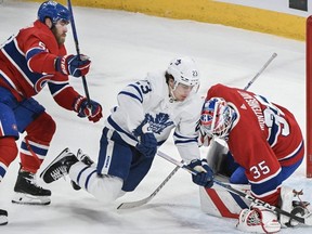 Maple Leafs forward Matthew Knies (23) moves in on Canadiens goaltender Sam Montembeault as David Savard defends during first period NHL action in Montreal, Saturday, March 9, 2024.
