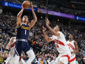 Denver Nuggets forward Michael Porter Jr., left, drives to the basket as Toronto Raptors center Jontay Porter (34) defends in the first half of an NBA basketball game Monday, March 11, 2024, in Denver.