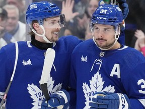 Toronto Maple Leafs' Auston Matthews (right) is congratulated by Simon Benoit after scoring his third goal against the Anaheim Ducks during second period NHL hockey action in Toronto, on Saturday, Feb. 17, 2024.