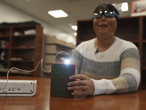 Minh Ha, assistive technology manager at the Perkins School for the Blind, tries a LightSound device for the first time at the school's library in Watertown, Mass., on March 2, 2024.