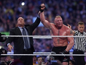 Paul Heyman, left, celebrates with Brock Lesnar after his win over the Undertaker during Wrestlemania XXX at the Mercedes-Benz Super Dome in New Orleans on Sunday, April 6, 2014.
