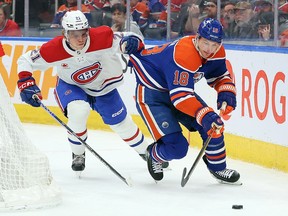 Kaiden Guhle of the Montreal Canadiens grabs onto Zach Hyman of the Edmonton Oilers at Rogers Place in Edmonton.