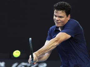 Milos Raonic of Canada plays a backhand return to Alex de Minaur of Australia during their first round match at the Australian Open tennis championships at Melbourne Park, Melbourne, Australia, Monday, Jan. 15, 2024.