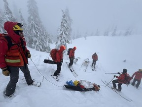 North Shore Rescue workers move a woman to safety along a trail near Pump Peak, in North Vancouver, B.C., in a Sunday, March 10, 2024, handout photo published to social media website Facebook. Rescuers say the woman is lucky to be alive after being caught in an avalanche on Metro Vancouver's North Shore and being completely buried upside down for up to 20 minutes.