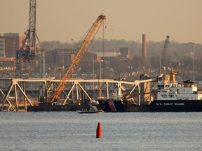 A crane works on the debris of the Francis Scott Key Bridge on March 29, 2024 in Baltimore, Maryland.