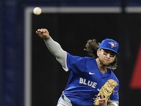 Toronto Blue Jays shortstop Bo Bichette makes a throwing error on a ground ball by Tampa Bay Rays' Yandy Diaz during the fifth inning of a baseball game Friday, March 29, 2024, in St. Petersburg, Fla.