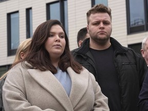 Ellie and Harry Baxter, the son and daughter of Stephen, 61, and Carol, 64, Baxter, stand outside Chelmsford Crown Court, in Chelmsford, England, Friday March 22, 2024 as a statement is read by the police after the sentencing of Luke D'Wit. D'Wit, a British IT worker who befriended and worked for Stephen and Carol Baxter, poisoned them with fentanyl and monitored their death with his cell phone was sentenced Friday to a minimum 37 years in prison.